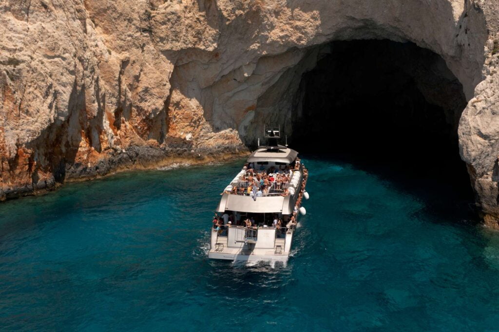 Vessel swimming and diving stop next to a sea cave